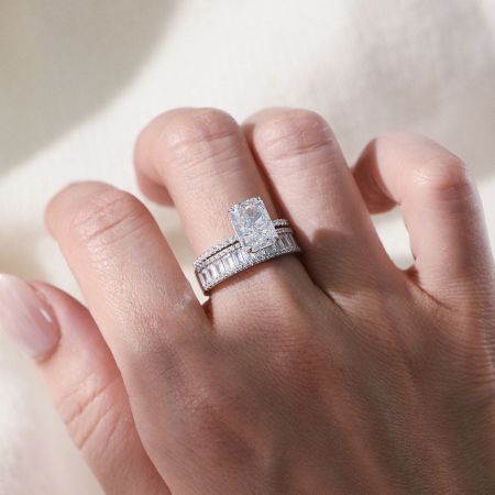 Angled product shot of the white gold tone radiant-cut CZ engagement ring on a neutral background.