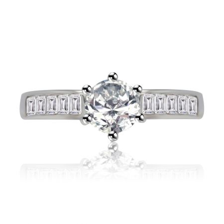 Band van bling-ring - Close-up van de Band of Bling Ring, een rhodium-geplateerde trouwring met een centrale rond geslepen cubic zirconia omringd door sprankelende smaragd en baguette-geslepen stenen.