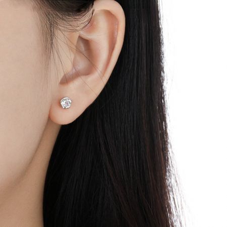 Close-up van een vrouw die de minimalistische 925 zilveren CZ stud oorbel draagt, die het elegante ontwerp toont.