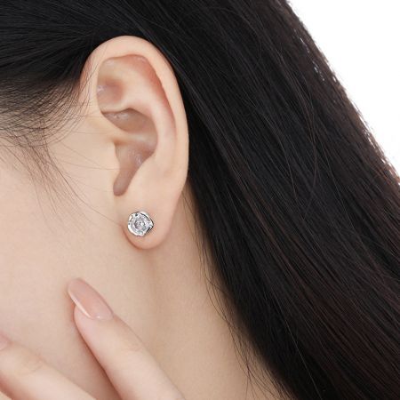 모델이 현대적이고 미니멀한 스타일을 강조하는 대형 불규칙 CZ 스터드 귀걸이를 선보입니다.