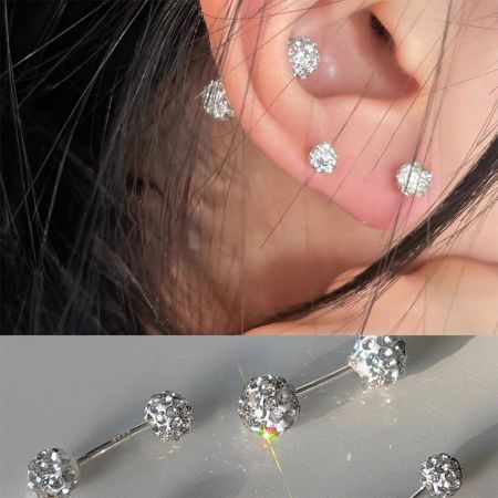 Primo piano di un orecchino a bottone in stile disco ball scintillante realizzato in argento 999 ipoallergenico.