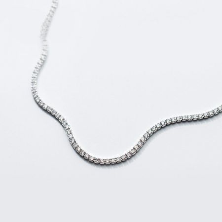 Un collier ras du cou en chaîne de tennis en argent sterling 925 magnifiquement conçu avec des zircons scintillants, présenté sur une surface blanche propre.