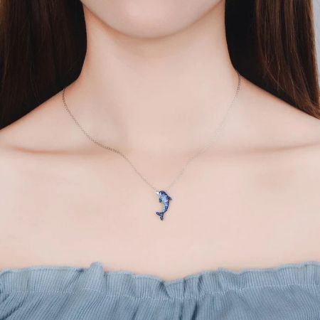 Collar de colgante de delfín de circonio azul de plata esterlina 925. - Un primer plano del collar de colgante de delfín de plata esterlina 925, mostrando las intrincadas piedras de circonio azul y claro en una cadena de plata.