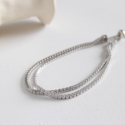 Detailaufnahme des luxuriösen doppelt-strängigen Silberarmbands, das die Brillanz der klaren Steine betont.