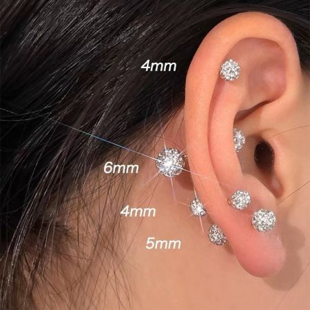 Esempio di come i diversi formati di orecchini a bottone a sfera di cristallo possano essere indossati su più fori all'orecchio.