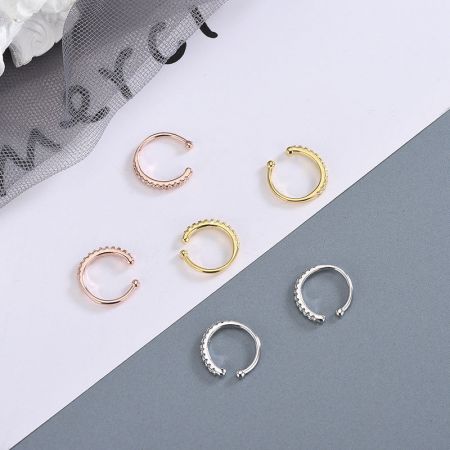 Orecchini a cuffia non forati in argento sterling 925 con CZ incastonati (5 paia) - Una collezione di orecchini a cuffia non forati in argento sterling 925 con pietre CZ, esposti in finiture argento, oro e oro rosa.
