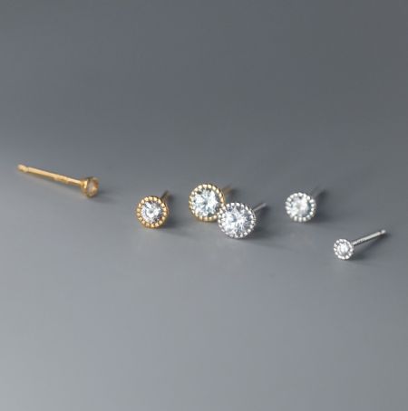 Orecchini a bottone Halo in argento sterling 925. - Un paio di orecchini a bottone Halo in argento sterling 925 con gemme in zirconia cubica trasparente, mostrati sia in opzioni di placcatura argento che oro.