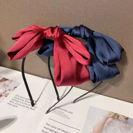 Diademas con lazo en rojo y azul marino, elegantes, exhibidas una al lado de la otra.