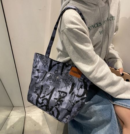 サイズとスタイルを示す手刷りトートバッグを持っているライフスタイル画像。