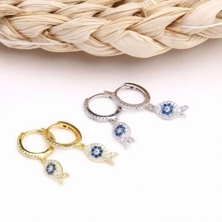 Un assortimento di orecchini a tema pesce in finiture oro e argento, decorati con gemme.