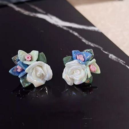 黒い大理石の表面に優雅に展示された花のイヤリング。