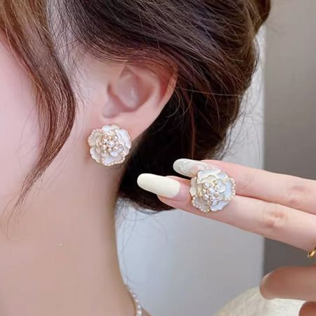 パールのディテールが施された椿の花のイヤリングとリングのセット。