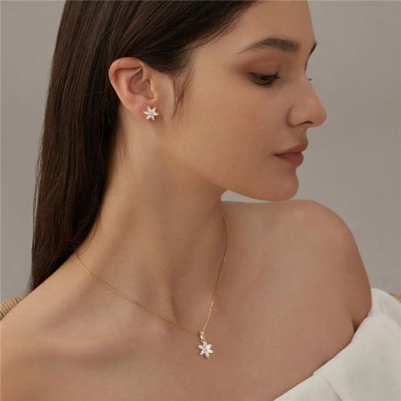 Une comparaison des versions en argent et en or de l'ensemble collier et boucles d'oreilles flocon de neige.