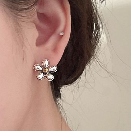 Gedetailleerd uitzicht op de antieke geoxideerde bloemenoorbel met duidelijke stenen accenten.