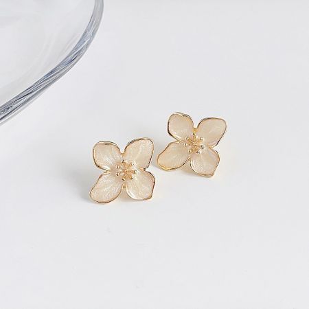 光沢のある素材と金のアクセントを示す花の形をしたピアスの詳細ショット。