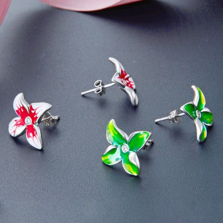 Orecchini a bottone a forma di fiore 3D in smalto rosso e verde in argento sterling 925 - Una collezione di orecchini a bottone a forma di fiore 3D in argento sterling 925 con dettagli in smalto rosso e verde vivace, esposti su uno sfondo scuro.