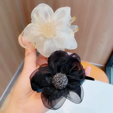 Close-up view of the beige and black flower-shaped hair clips.