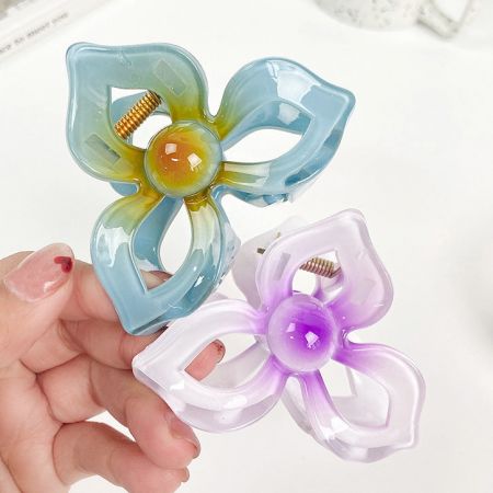 Twee bloemenvormige haarclips in verschillende kleuren.