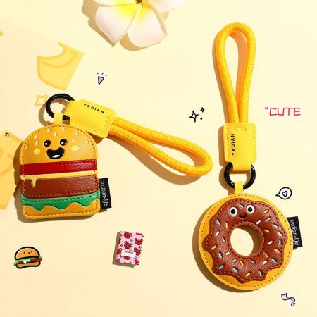 Een paar voedsel-thema sleutelhangers met de hamburger en donut ontwerpen naast elkaar.