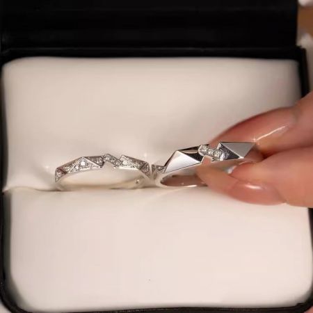 Eine Nahaufnahme der passenden silbernen Origami-Ringe mit Zirkonia-Steinen, die in einer Schmuckschatulle präsentiert werden.