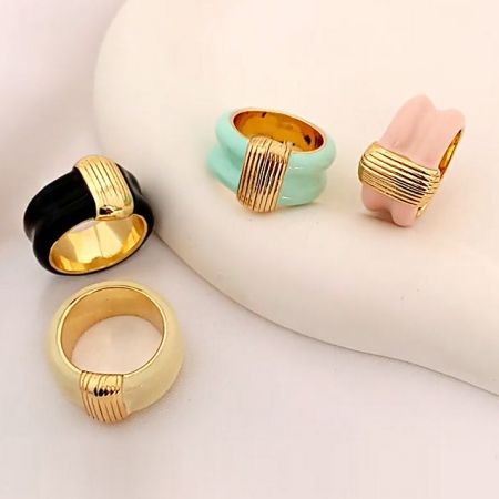 Bagues en émail vintage en laiton plaqué or de style français - Un ensemble de cinq bagues en émail vintage de style français dans différentes couleurs, fabriquées en laiton plaqué or, exposées ensemble.