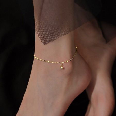 925 Sterling Zilveren Enkelband voor Vrouwen Zomer Strand Sieraden - Een close-up van een 925 sterling zilveren enkelband in een gouden tint, met een minimalistisch kattenvormig bedeltje met een centrale blauwe cubic zirconia steen.