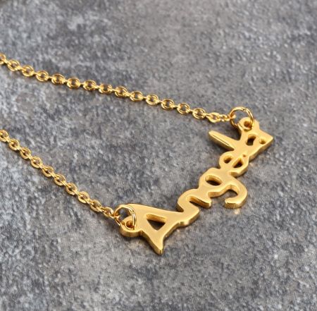 Voorbeeld van een gepersonaliseerde 'Aries' sterrenbeeld naamketting in verguld.