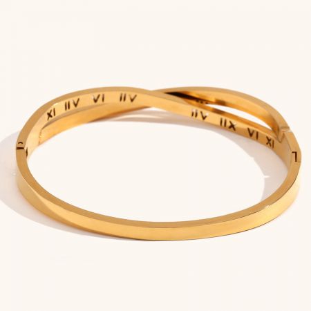 クラシックで時代を超えた美学を強調する金のローマ数字バングルのペアが展示されています。