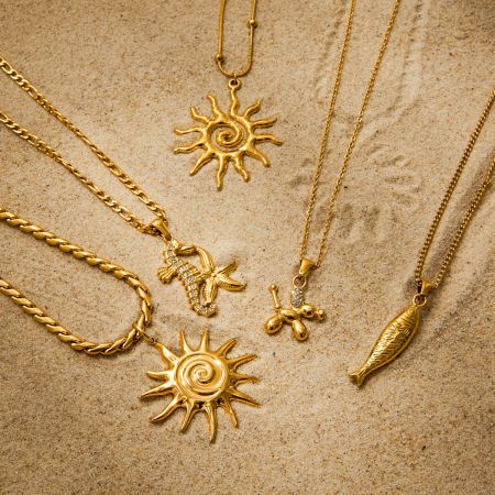 Primer plano del conjunto de collares con colgante de sol dorado, destacando el material de acero inoxidable impermeable e hipoalergénico.
