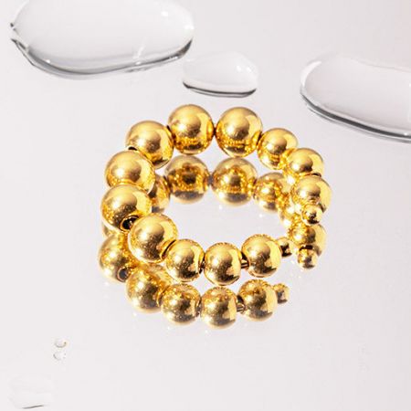 Meerdere gouden kralenarmbanden samen tentoongesteld.