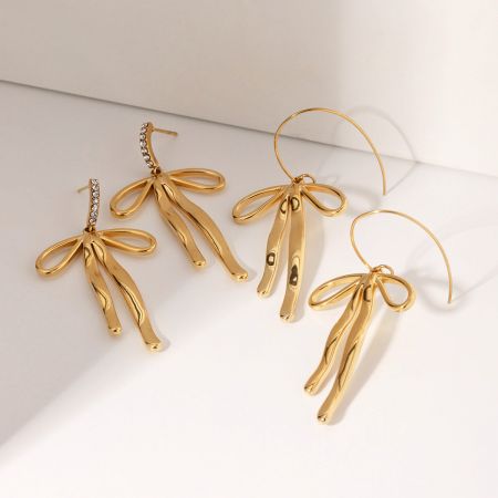 Productfoto van de gouden roestvrijstalen strik oorbellen met verschillende bevestigingsopties.