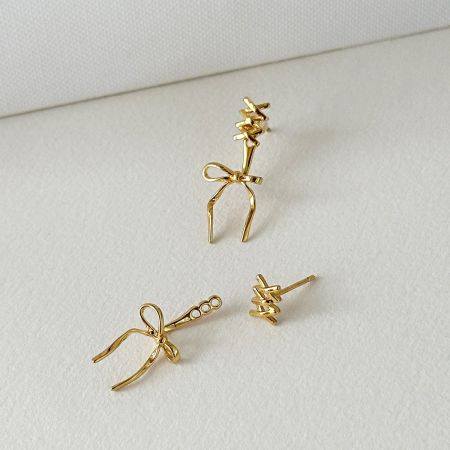 Närbild av de guldpläterade 925 sterling silver båge-studörhängena.