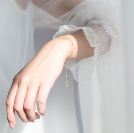 925 Sterling Zilveren Gouden Geplateerde Dubbele Kettingarmband - Een model dat de 925 Sterling Zilveren Gouden Geplateerde Dubbele Kettingarmband draagt, die het elegante ontwerp op de pols toont.