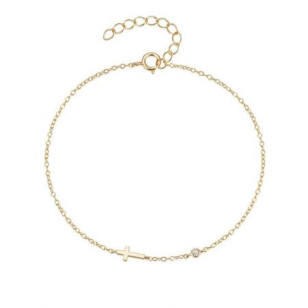 Detailed studio shot of the gold cross charm bracelet with a brilliant cubic zirconia accent.