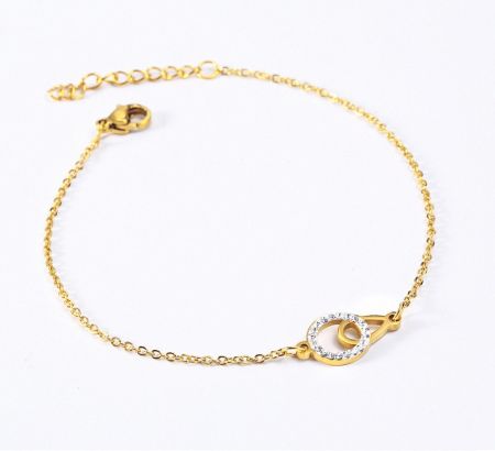 Pulsera chapada en oro con un diseño de círculos entrelazados adornada con piedras blancas brillantes.