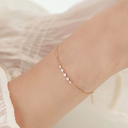 Le bracelet en zircon plaqué or porté au poignet, mettant en valeur son ajustement élégant.