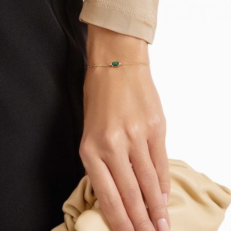 La pulsera de plata esterlina 925 con piedra preciosa verde exhibida sobre un fondo neutro para resaltar su acabado dorado.