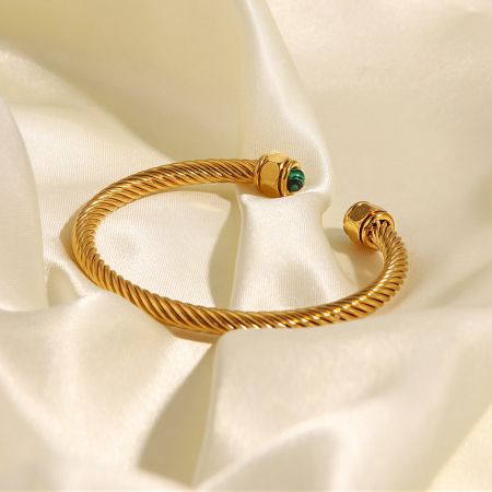Sidoprofil av det vridna öppna armbandet, som visar den cylindriska inställningen av den gröna ädelstenen.
