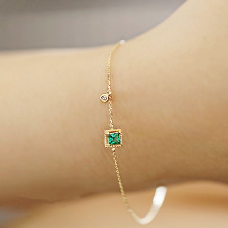 Conjunto de 5 pulseras chapadas en oro de plata esterlina 925 con zirconia verde esmeralda al por mayor - Primer plano de una pulsera chapada en oro de plata esterlina 925 que presenta un zircon cuadrado verde esmeralda y una pequeña piedra preciosa clara.