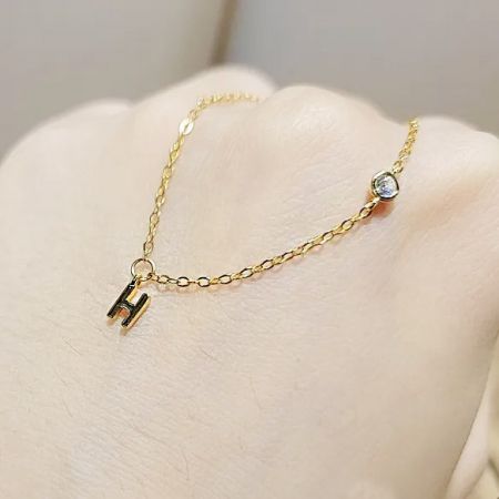 Close-up of the bracelet on a wrist, highlighting the H charm and crystal detail.