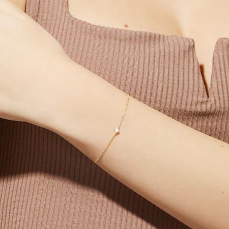 Primo piano del bracciale in opale dorato sul braccio di una persona.