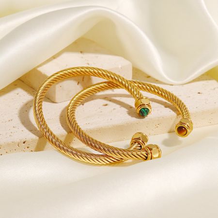 Närbild av de rostfria stålvridna pave öppna armbanden, som framhäver detaljerna av naturliga stenar.