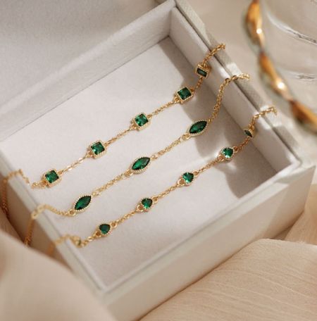 925 Sterling Zilveren Smaragdarmband - Een set van drie 925 Sterling Zilveren Smaragdarmbanden met vergulding, met levendige groene cubic zirconia, elegant gepresenteerd in een witte juwelendoos.