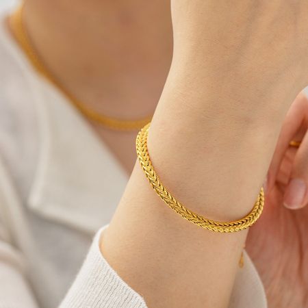 Roestvrijstalen retro brede curb kettingarmbanden - Set van 5 - Een close-up van een persoon die de vergulde roestvrijstalen retro brede curb kettingarmband draagt, met een blik op het gedetailleerde ontwerp.