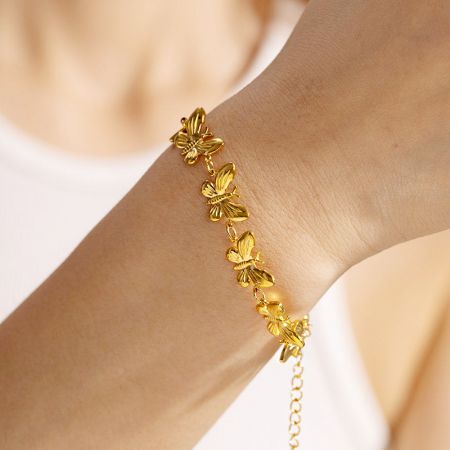 Pulsera de cadena de mariposa elegante mostrada en una muñeca, destacando su diseño delicado.