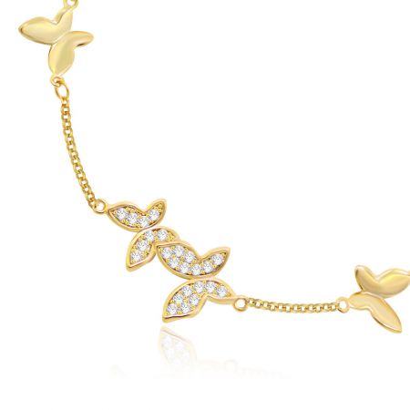 Close-up view of the gold-toned butterfly charm bracelet, highlighting the intricate details of the clear stones.