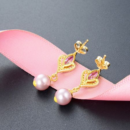 Orecchino con design alternativo a farfalla con gemme rosa e perla, che mostra la versatilità del design.