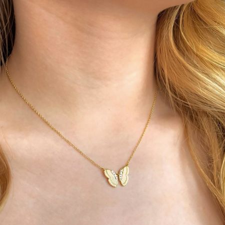 Modèle portant le collier pendentif en or en forme de papillon élégant pour mettre en valeur sa taille et son style.