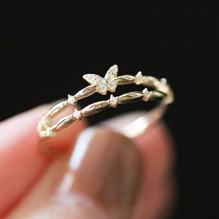 クリーンな白い背景にある金のバタフライオープンリングの詳細な商品写真。