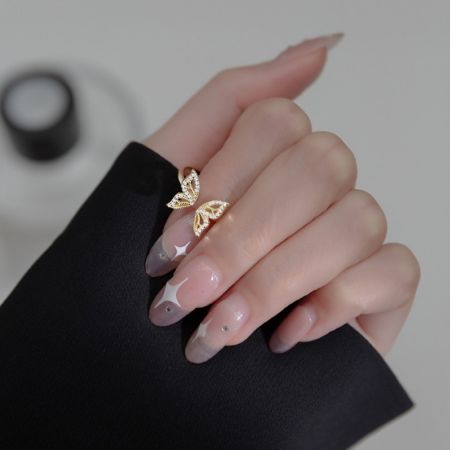 A model's hand wearing the rose-gold plated version of the butterfly ring.